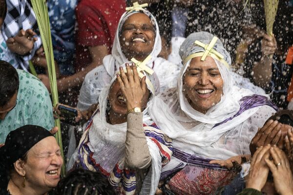 Cristianos etíopes y egipcios son rociados con agua bendita durante la misa del Domingo de Ramos en Egipto. - Sputnik Mundo