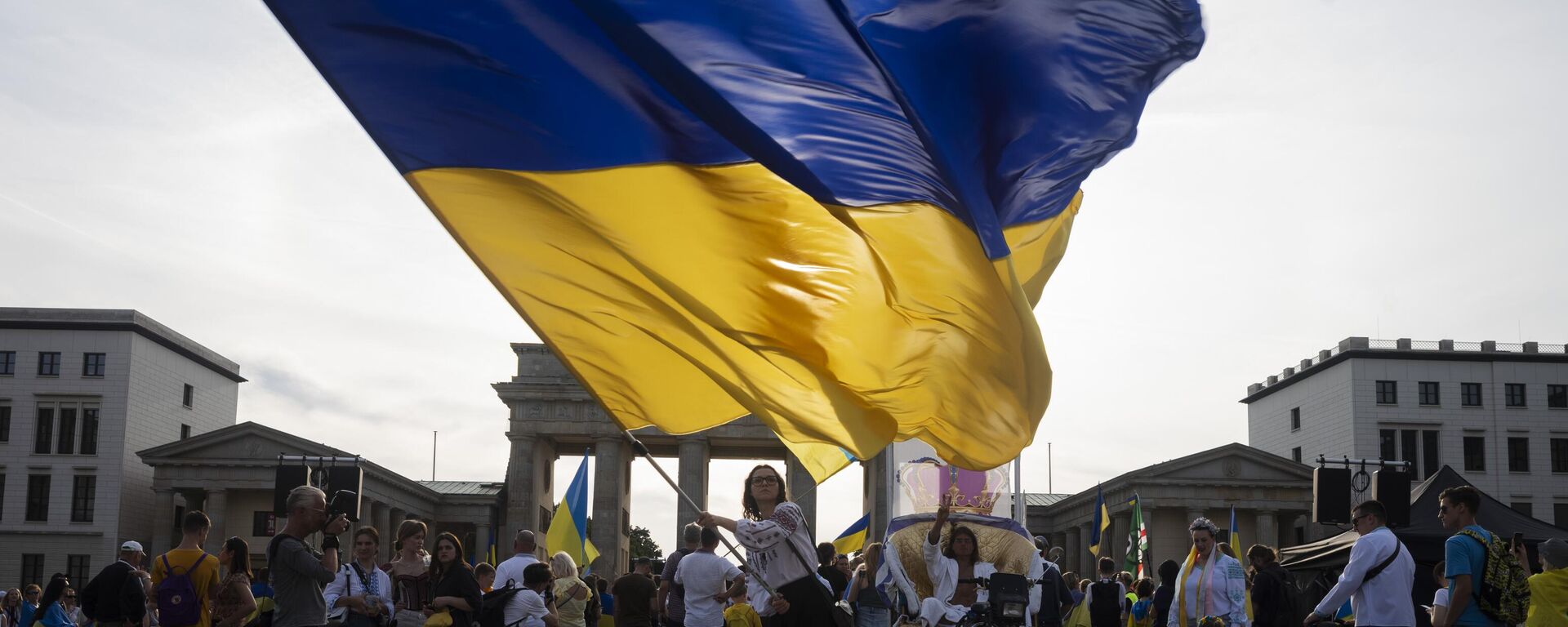 Una mujer ondea una enorme bandera ucraniana durante la manifestación para conmemorar el 32.° aniversario de la independencia de Ucrania en Berlín, Alemania, el 24 de agosto de 2023  - Sputnik Mundo, 1920, 29.04.2024