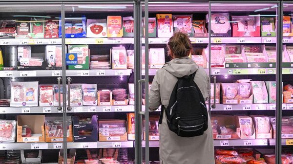 Una mujer recoge artículos de un estante de la sección de refrigerados en una tienda de la cadena de supermercados Penny en Berlín, Alemania, el 1 de agosto de 2023 - Sputnik Mundo