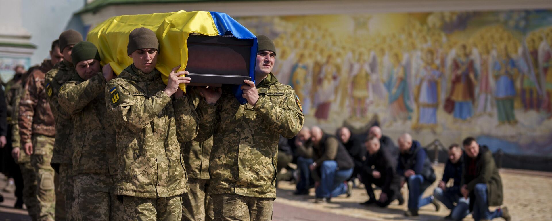 Varias personas se arrodillan mientras militares ucranianos transportan el ataúd de un soldado muerto - Sputnik Mundo, 1920, 30.04.2024