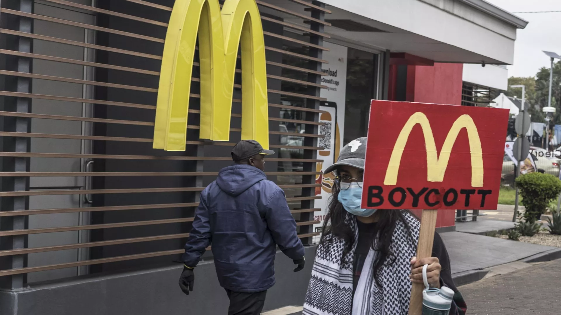 Un manifestante con una pancarta que pide boicotear la cadena de comida rápida McDonald's por su apoyo a Israel  - Sputnik Mundo, 1920, 30.04.2024