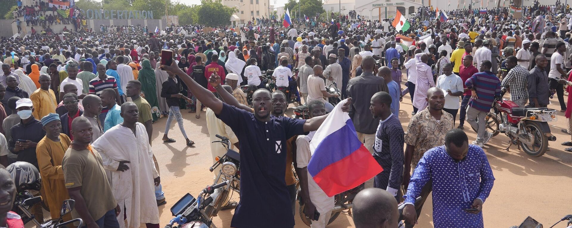 Partidarios de la junta gobernante de Níger sostienen una bandera rusa al comienzo de una protesta convocada para luchar por la libertad del país  - Sputnik Mundo, 1920, 01.05.2024