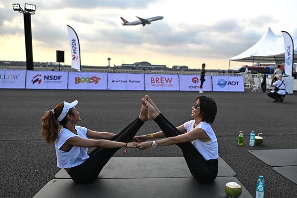 Aficionados al yoga lo practican durante el evento Brew Yoga en la pista del aeropuerto de Suvarnabhumi, en Bangkok, Tailandia. - Sputnik Mundo