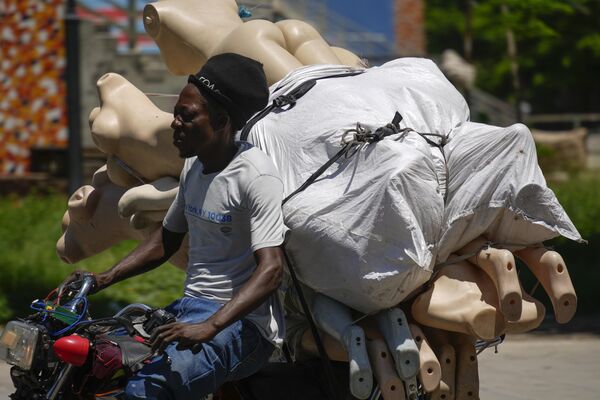 Un vendedor ambulante retirando sus mercancías luego de que se produjeran disparos cerca del Palacio Nacional en Puerto Príncipe, Haití. - Sputnik Mundo