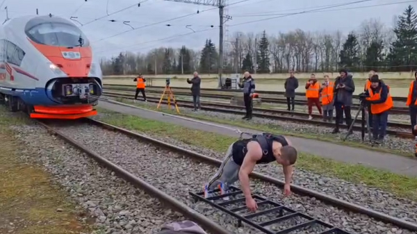El atleta de ruso Denís Vovk trasladó un tren Sapsán de 650 toneladas a una distancia de 1,48 metros en solo 37 segundos y batió el récord mundial, el 7 de mayo, 2024 - Sputnik Mundo
