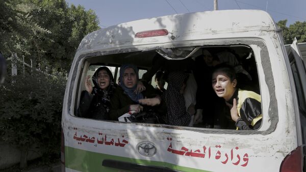 Palestinos desplazados que habían perdido a sus familiares en un ataque aéreo israelí contra una escuela de la ONU lloran mientras abandonan el hospital para buscar otro refugio, el 24 de julio, 2014 - Sputnik Mundo