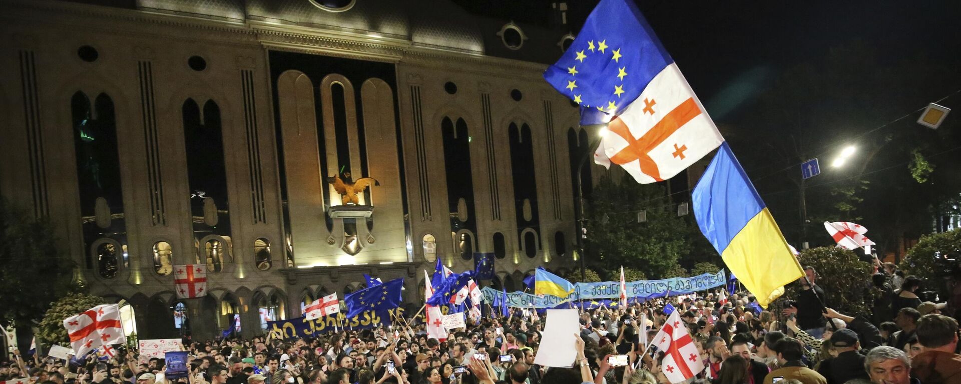 Manifestantes con banderas nacionales de Georgia y Ucrania y de la UE reunidos ante el edificio del Parlamento para protestar contra la ley sobre agentes extranjeros, el 28 de abril, 2024 - Sputnik Mundo, 1920, 08.05.2024