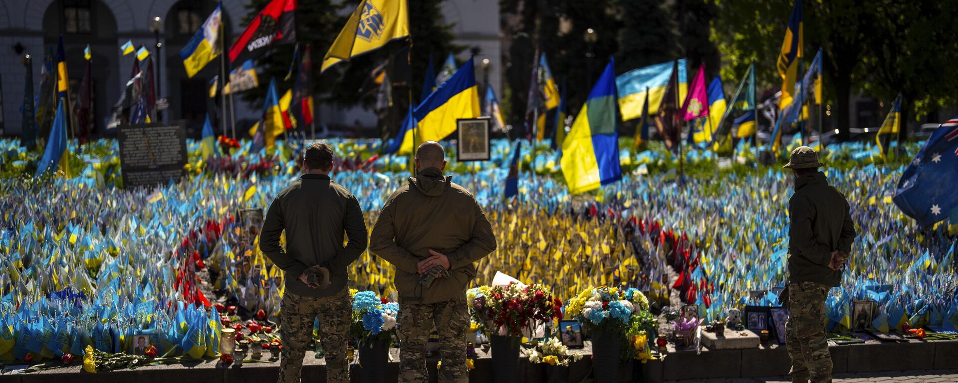 Militares ucranianos junto a banderas ucranianas y fotografías colocadas en memoria de los soldados muertos, en la plaza de la Independencia, en el centro de Kiev, el 20 de abril de 2024  - Sputnik Mundo, 1920, 13.05.2024
