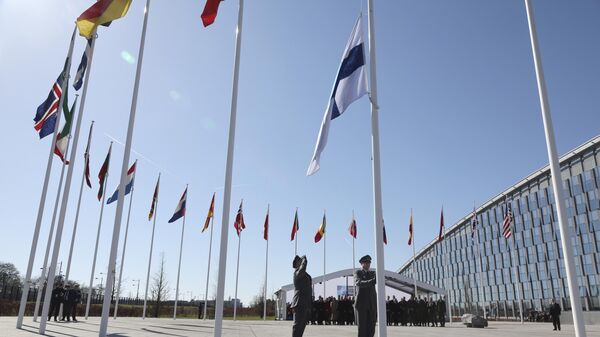 Personal militar iza la bandera de Finlandia en la sede de la OTAN en Bruselas (archivo)  - Sputnik Mundo