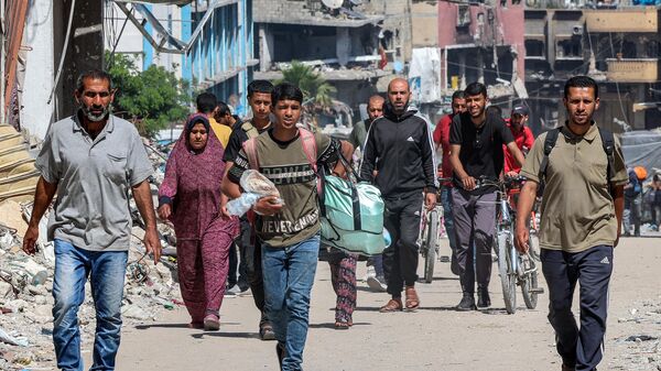Palestinos caminan a través de edificios destruidos por Israel en Jabalia, en el norte de la Franja de Gaza (archivo)  - Sputnik Mundo