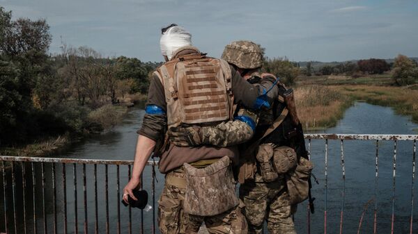 Un militar ucraniano herido cruza el puente sobre el río Oskil en Kúpiansk, el 30 de septiembre de 2022 - Sputnik Mundo