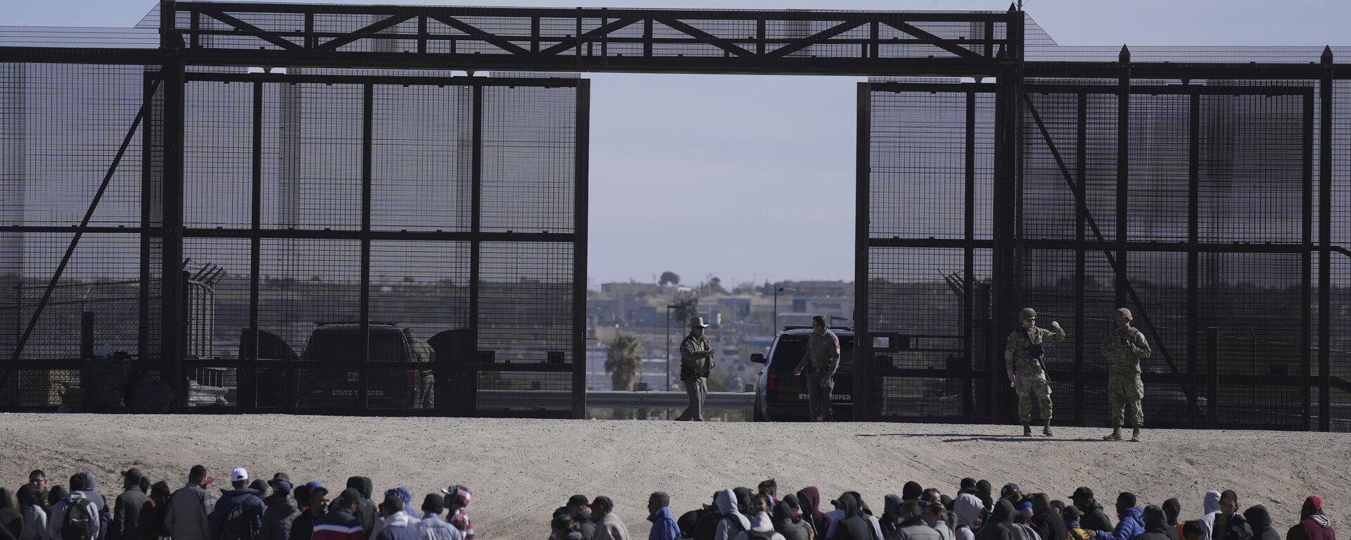 Migrantes que cruzaron la frontera de México hacia Estados Unidos esperan junto al muro fronterizo, donde hacen guardia agentes de la Patrulla Fronteriza (archivo)  - Sputnik Mundo, 1920, 16.05.2024