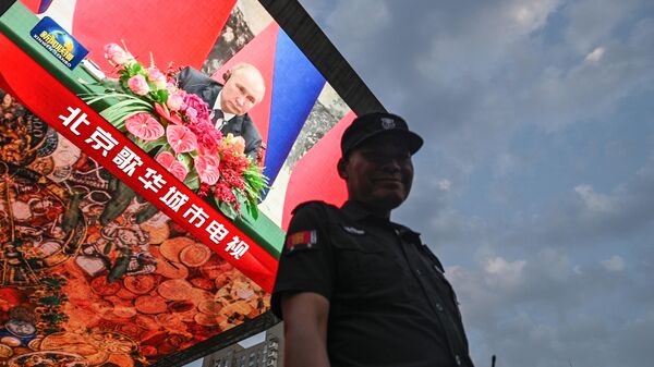 La visita del presidente ruso Vladímir Putin a China, en una pantalla gigante en Pekín - Sputnik Mundo