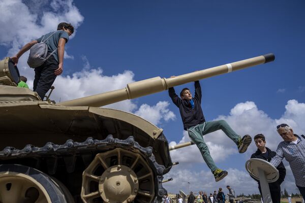 Un grupo de israelíes subidos a un tanque durante el Día de la Conmemoración Anual de los Soldados Caídos en Latrún, Israel. - Sputnik Mundo