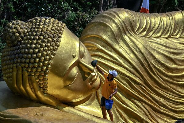 Una persona limpiando una estatua de Buda en el templo Maha Vihara Mojopahit, en Mojokerto (Indonesia) antes del festival de Vesak, que conmemora el nacimiento, la iluminación y la muerte de Buda. - Sputnik Mundo