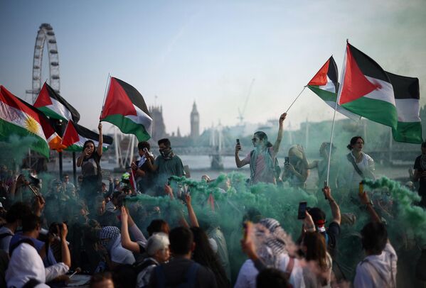 Manifestantes ondeando banderas palestinas durante una manifestación pro-Palestina en el puente de Waterloo, en Londres. - Sputnik Mundo