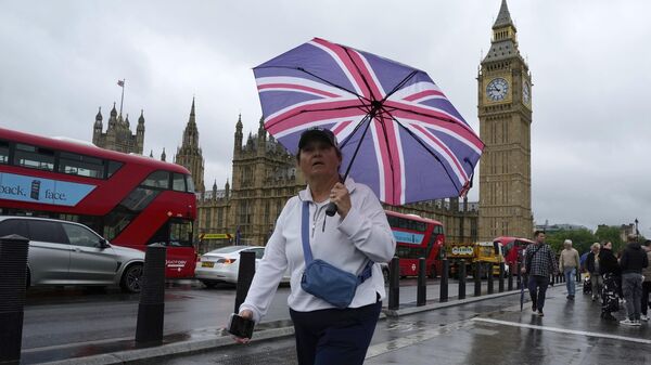 Una mujer camina frente al Parlamento, en Londres, el 22 de mayo de 2024  - Sputnik Mundo