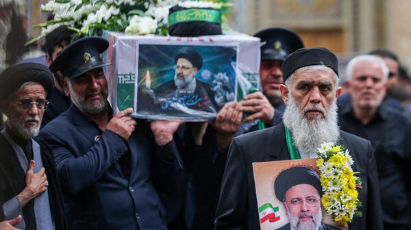 Un miembro de la guardia de honor llora mientras lleva el féretro del presidente iraní Ebrahim Raisi durante un cortejo fúnebre, el 21 de mayo de 2024 - Sputnik Mundo