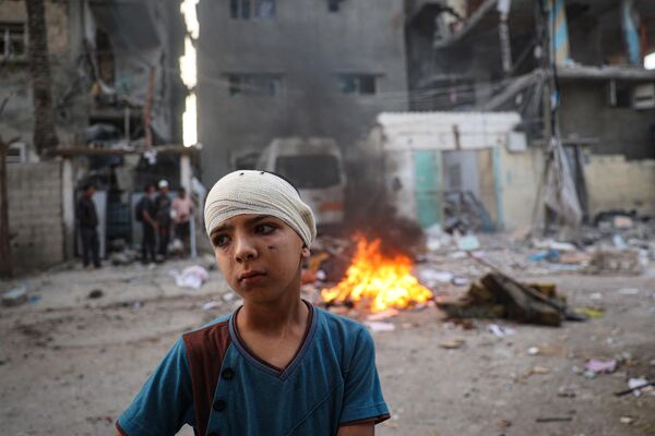 Un niño palestino herido cerca de una casa afectada por los bombardeos israelíes en Rafah, sur de la Franja de Gaza. - Sputnik Mundo