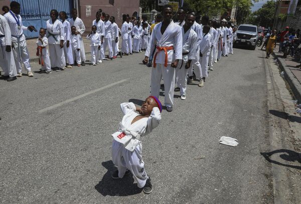 Un niño vestido de karateca participando en un desfile con motivo del Día de la Bandera en Haití. - Sputnik Mundo