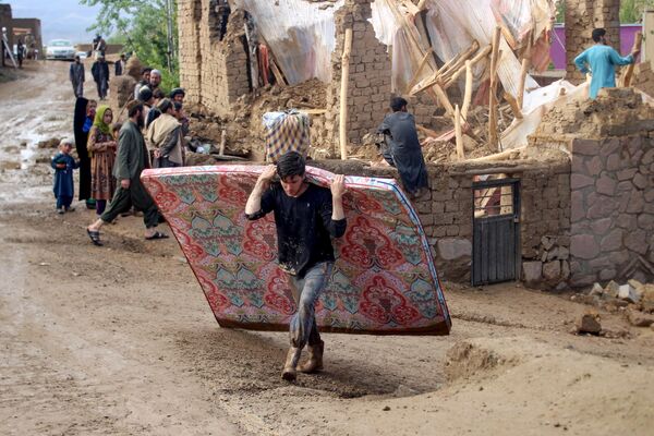 Residentes retirando escombros y rescatando pertenencias en una casa dañada por las inundaciones en la provincia afgana de Ghor.Las inundaciones repentinas, causadas por las fuertes lluvias, han dejado varios centenares de muertos en el país. - Sputnik Mundo