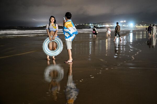 Un grupo de personas tomándose fotos en una playa de la isla de Pingtan, el punto de China continental más cercano a Taiwán. - Sputnik Mundo