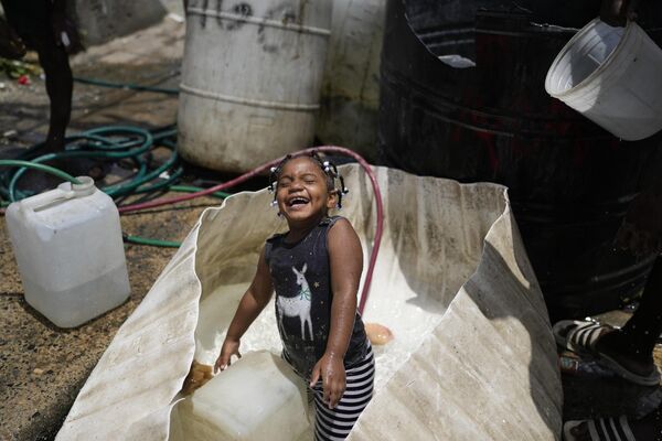 Una niña jugando con agua en Santo Domingo, República Dominicana. - Sputnik Mundo