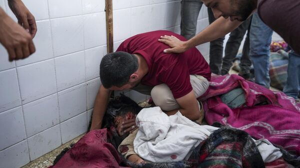 Un hombre palestino llora sobre el cadáver de su familiar asesinado por Israel durante los bombardeos del domingo contra un campamento de refugiados en Rafah  - Sputnik Mundo