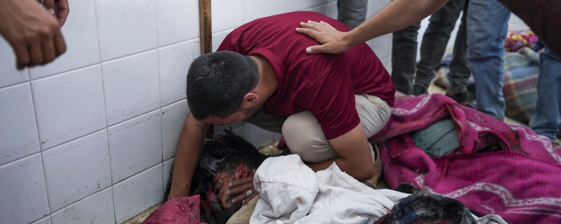 Un hombre palestino llora sobre el cadáver de su familiar asesinado por Israel durante los bombardeos del domingo contra un campamento de refugiados en Rafah  - Sputnik Mundo, 1920, 19.06.2024