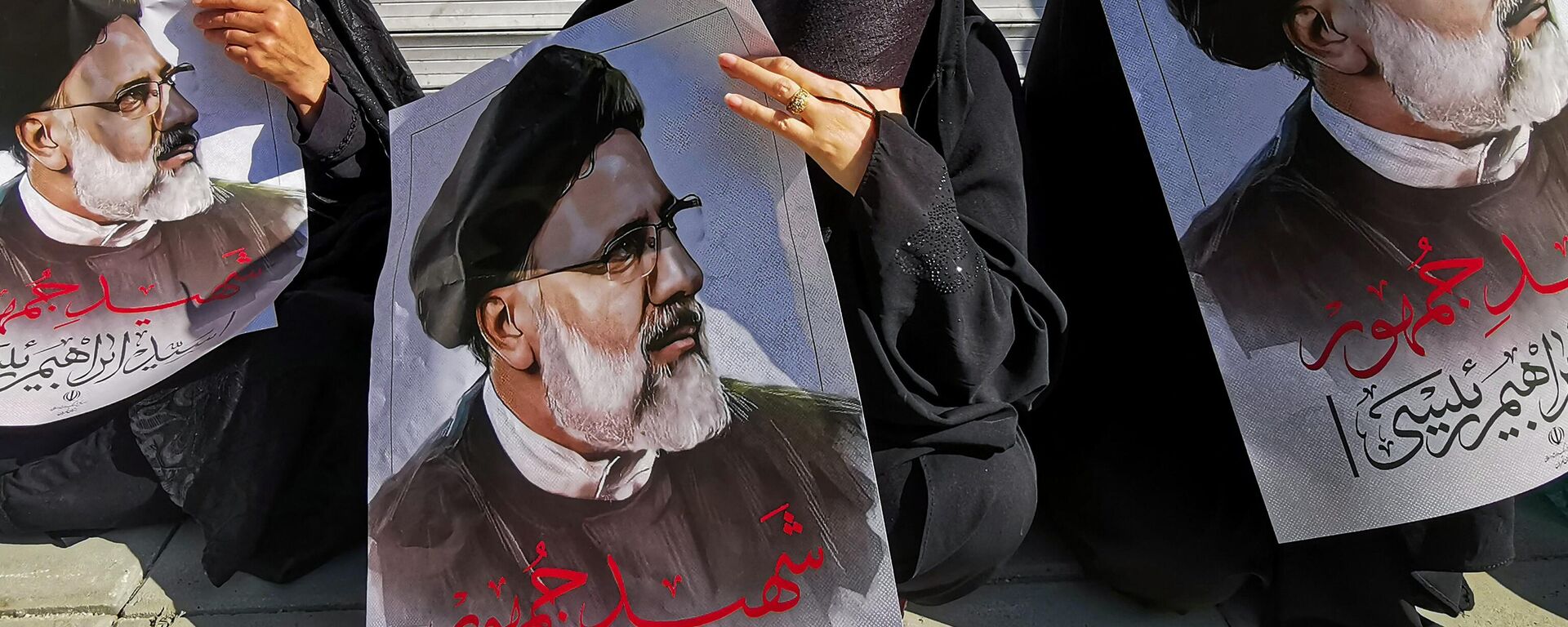 Los dolientes sostienen carteles del presidente iraní Ebrahim Raisi durante una procesión fúnebre por él y otros funcionarios, que murieron en un accidente de helicóptero, en Teherán el 22 de mayo de 2024  - Sputnik Mundo, 1920, 30.05.2024