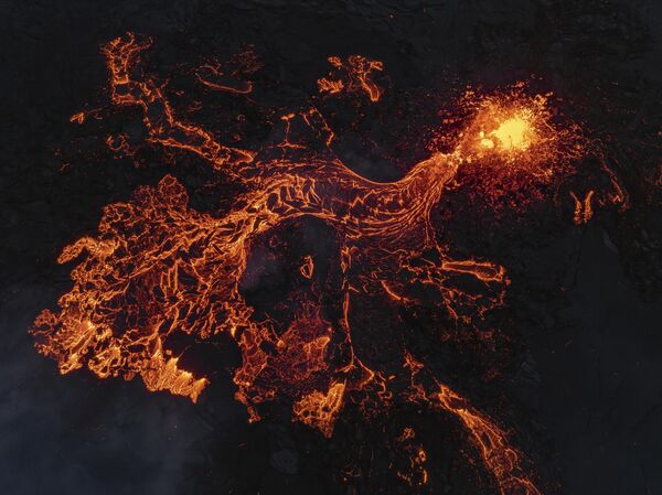 Un volcán una vez más amenazó la ciudad costera de Grindavik y llevó a la evacuación del popular balneario geotérmico Blue Lagoon.En la foto: flujos de lava de un volcán en Grindavik. - Sputnik Mundo