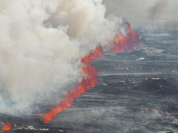 Una fisura eruptiva arroja lava y humo desde un volcán en Grindavik. - Sputnik Mundo