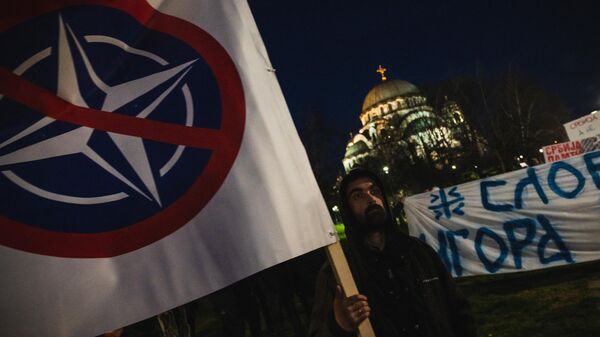 Varias personas sostienen una pancarta en la que se lee No a la OTAN durante una protesta en Belgrado (Imagen referencial) - Sputnik Mundo