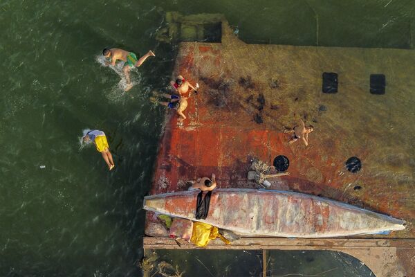 Unos niños nadan cerca de un barco hundido en el río Chat el Arab en Irak. - Sputnik Mundo