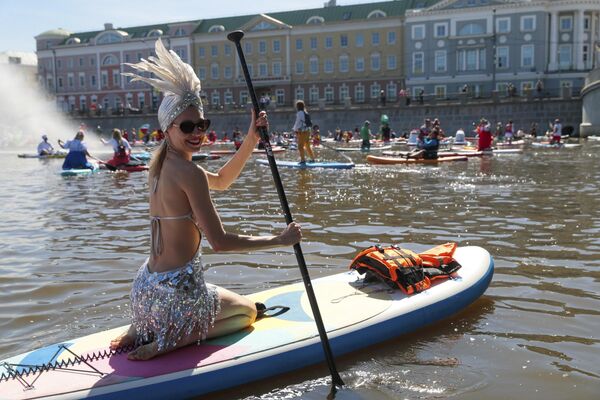 Personas dirigen sus tablas de surf a pala (SUP) a lo largo del canal del río Moscú durante un festival, en Rusia. - Sputnik Mundo
