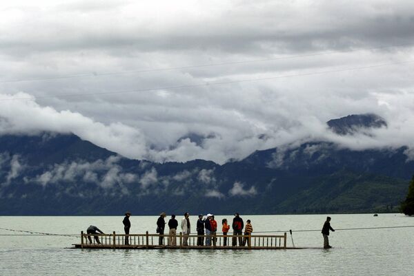 Los científicos también evaluaron los riesgos resultantes para la infraestructura esencial, los asentamientos humanos y los componentes clave del ecosistema.En la foto: turistas chinos saliendo en transbordador desde una isla del lago Basongcuo, en la región de Nyingchi, en el sureste del Tíbet, el 18 de agosto de 2004. - Sputnik Mundo