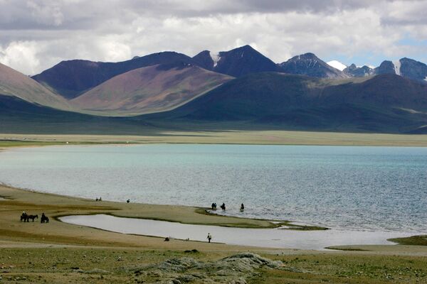En la foto: tibetanos y turistas paseando y cabalgando por las orillas del lago Namtso, en la meseta tibetana del condado de Naqu. - Sputnik Mundo