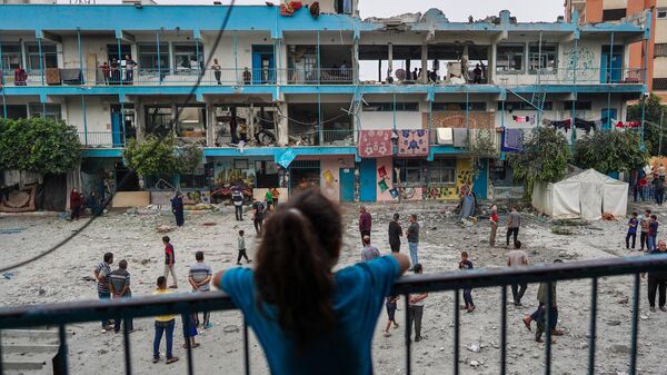 El 6 de junio de 2024, una niña palestina observa una escuela de la ONU que alberga a personas desplazadas y que fue alcanzada durante un bombardeo israelí en Nuseirat, en el centro de la Franja de Gaza. - Sputnik Mundo