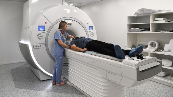 El personal de un centro médico ajusta la máquina de resonancia magnética - Sputnik Mundo
