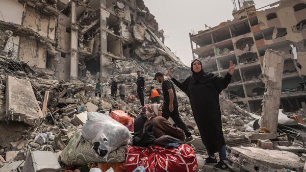 Los palestinos inspeccionan los daños a un edificio en la ciudad de Nuseirat, en el centro de la Franja de Gaza  - Sputnik Mundo