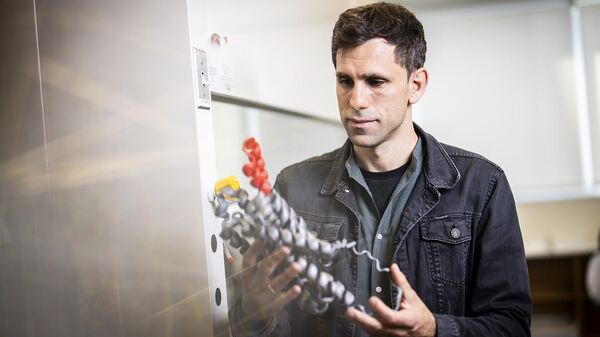 El profesor César de la Fuente, con un modelo de molécula con propiedades antibióticas hallada en un mamut - Sputnik Mundo
