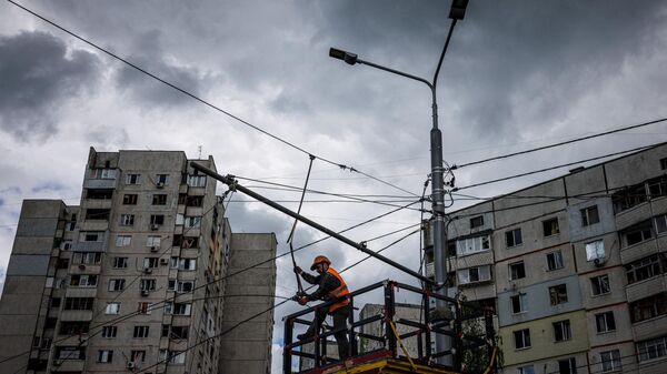 Un trabajador comunal repara las líneas eléctricas cortadas por los bombardeos en Járkov, el 15 de mayo de 2022  - Sputnik Mundo