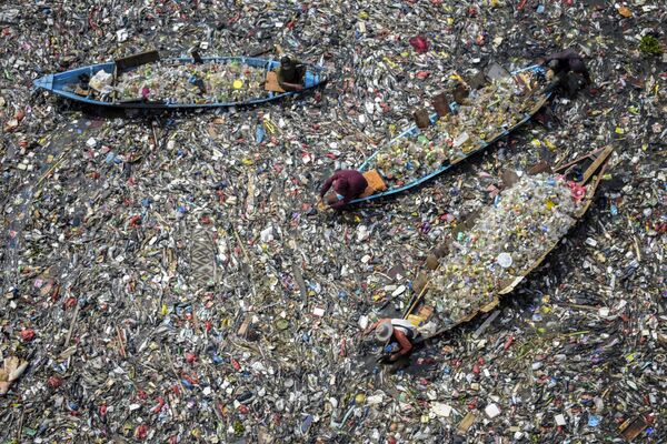 Un grupo de hombres recoge plástico reciclable del río Citarum, muy contaminado, en Batujahara, Bandung (Java Occidental, Indonesia). - Sputnik Mundo