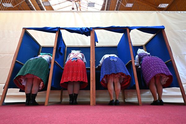 Mujeres con trajes tradicionales húngaros rellenan sus papeletas en un colegio electoral, Hungría. - Sputnik Mundo