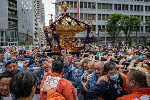 Participantes transportan un templo portátil por las calles durante el festival Tsukiji Shishi Matsuri o Festival de la Danza del León se celebra cada año en junio en el santuario Namiyoke Inari Jinja del distrito de Tsukiji, en Tokio, Japón. - Sputnik Mundo