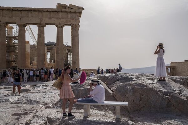 Turistas frente al Partenón en la antigua Acrópolis de Atenas, Grecia. El antiguo yacimiento permaneció cerrado al público durante cinco horas debido a una ola de calor que elevó las temperaturas a 39 ºC. - Sputnik Mundo