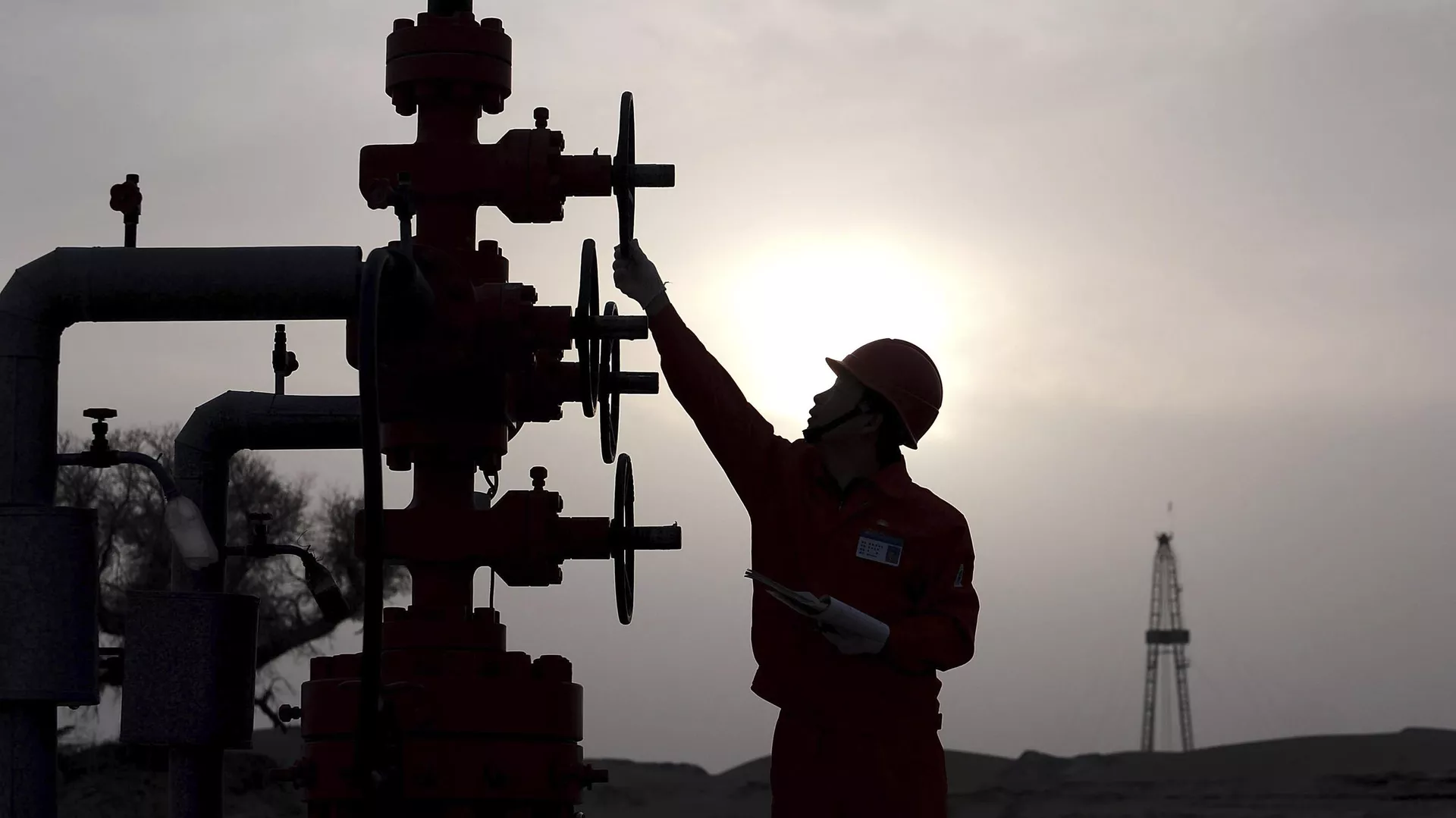 Trabajador comprueba las tuberías del yacimiento petrolífero Tarim de PetroChina, en el desierto de Taklamakán, en la región occidental de Xinjiang, China, 26 de marzo de 2009 - Sputnik Mundo, 1920, 03.08.2024