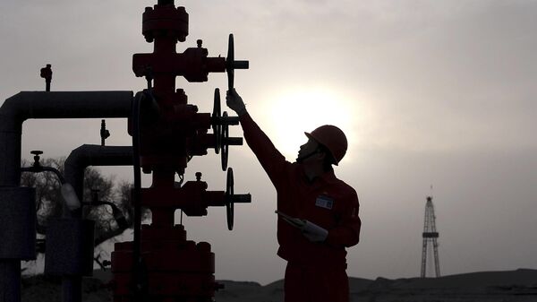 Trabajador comprueba las tuberías del yacimiento petrolífero Tarim de PetroChina, en el desierto de Taklamakán, en la región occidental de Xinjiang, China, 26 de marzo de 2009 - Sputnik Mundo