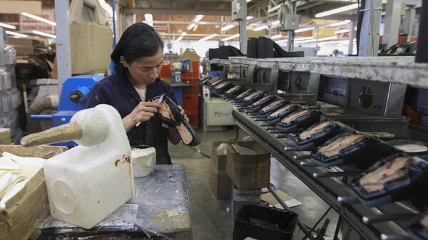 Una mujer trabaja en la maquiladora de zapatos (archivo) - Sputnik Mundo