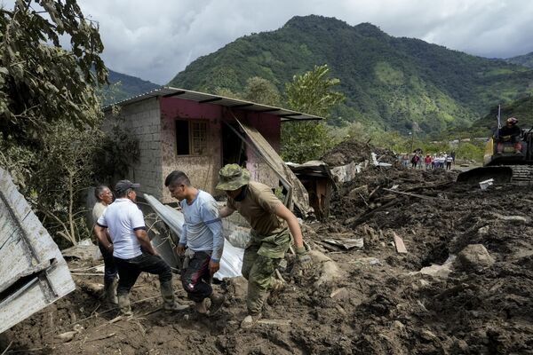 Residentes reaccionan después de que los deslizamientos de tierra dañaran su casa en El Placer, Ecuador. - Sputnik Mundo